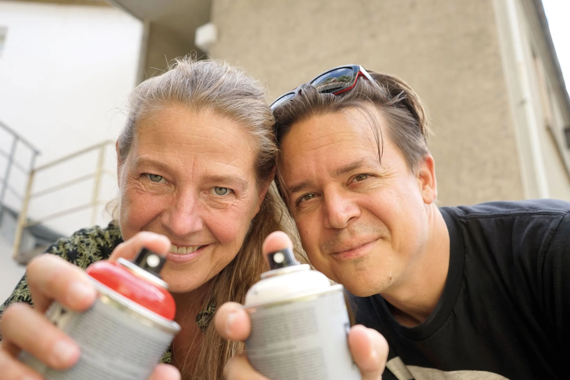 Monika und Marco Niedermann halten Spraydosen in die Kamera